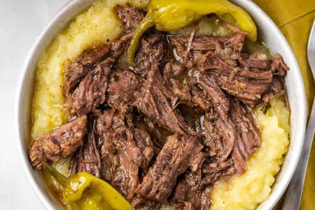 Mississippi pot roast in a bowl with mashed potatoes.