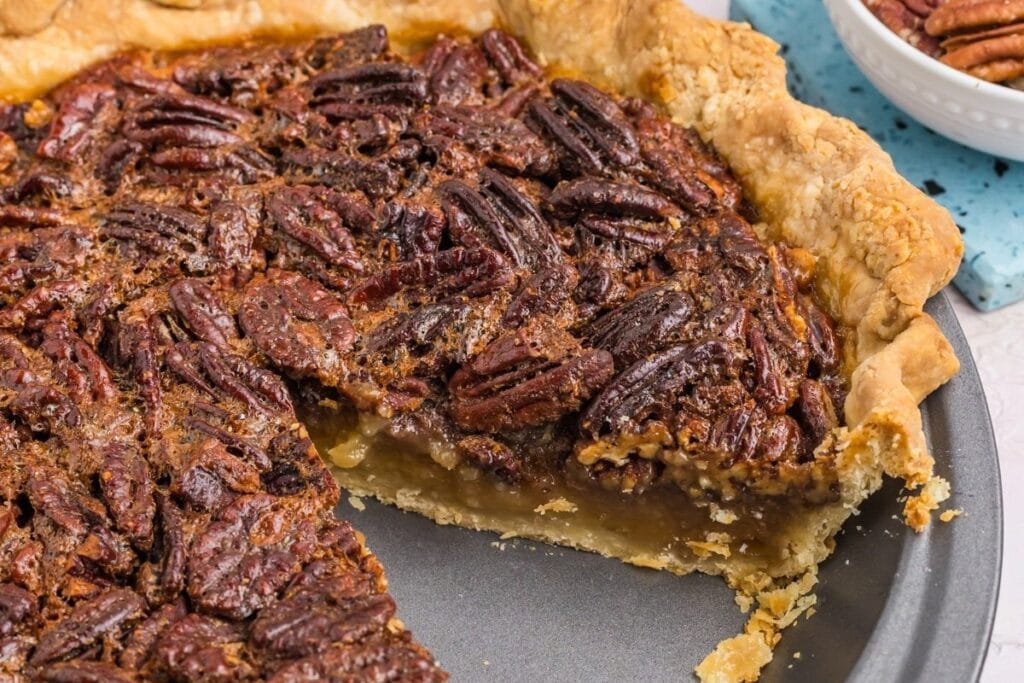 Old-fashioned pecan pie close-up with one slice taken out.