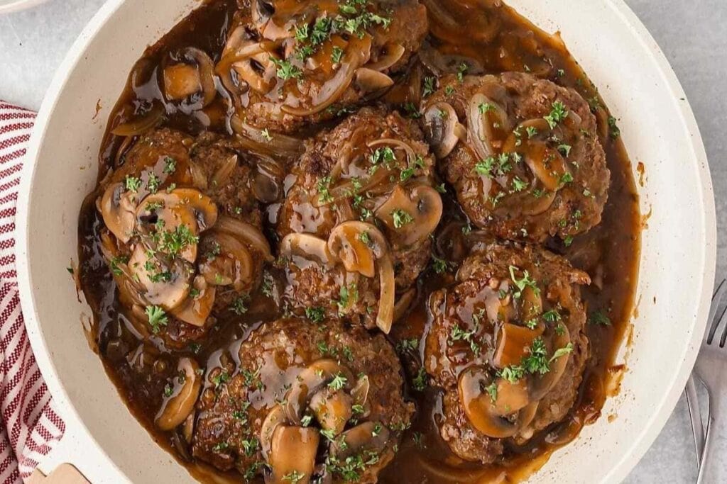 Old fashioned Salisbury steak in a skillet.