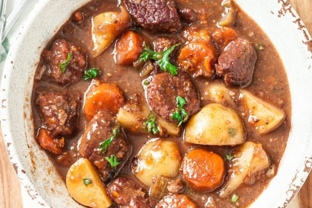 Beef stew with potatoes and carrots served in a bowl.