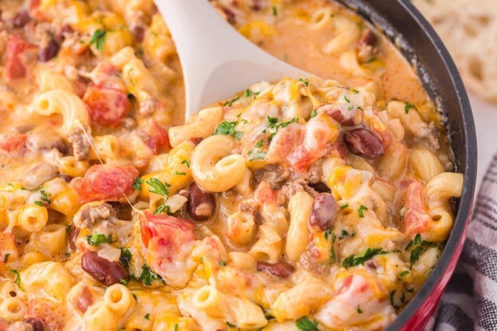 One-pot chili mac in pot with serving spoon.