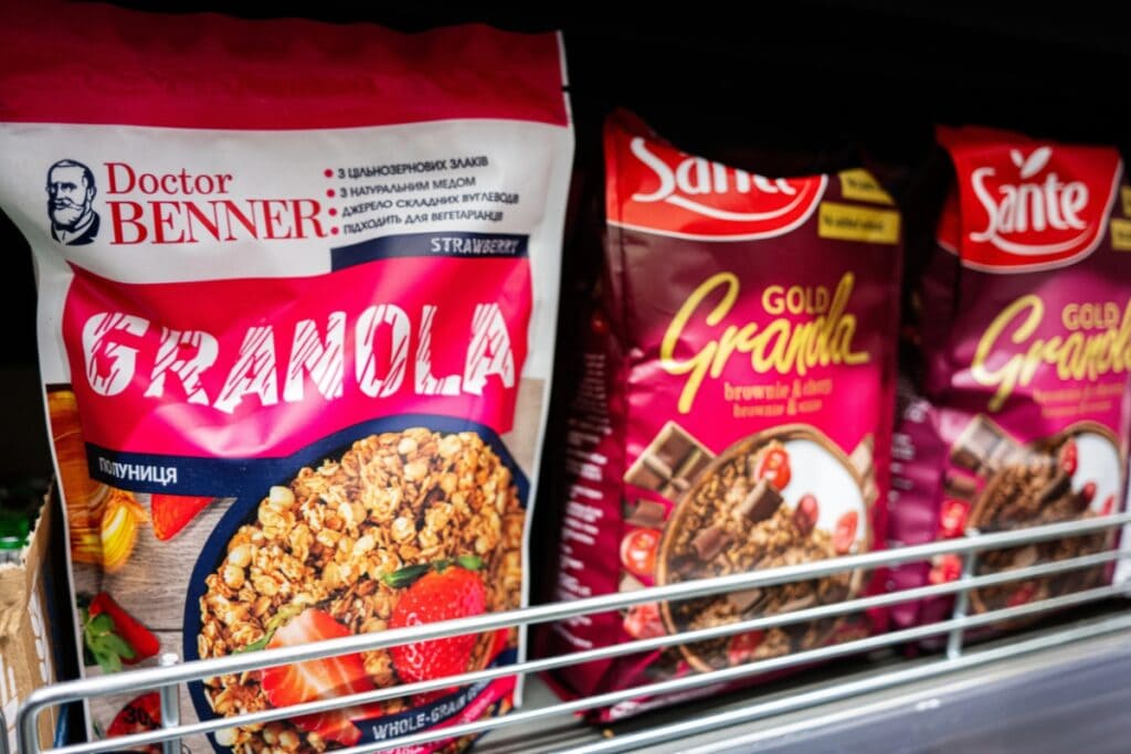 Bags of granola lined up on a supermarket shelf.