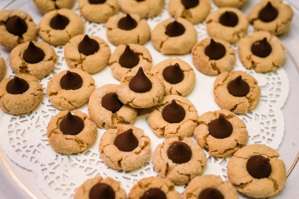 Peanut butter blossom cookies on a cloth-covered table.