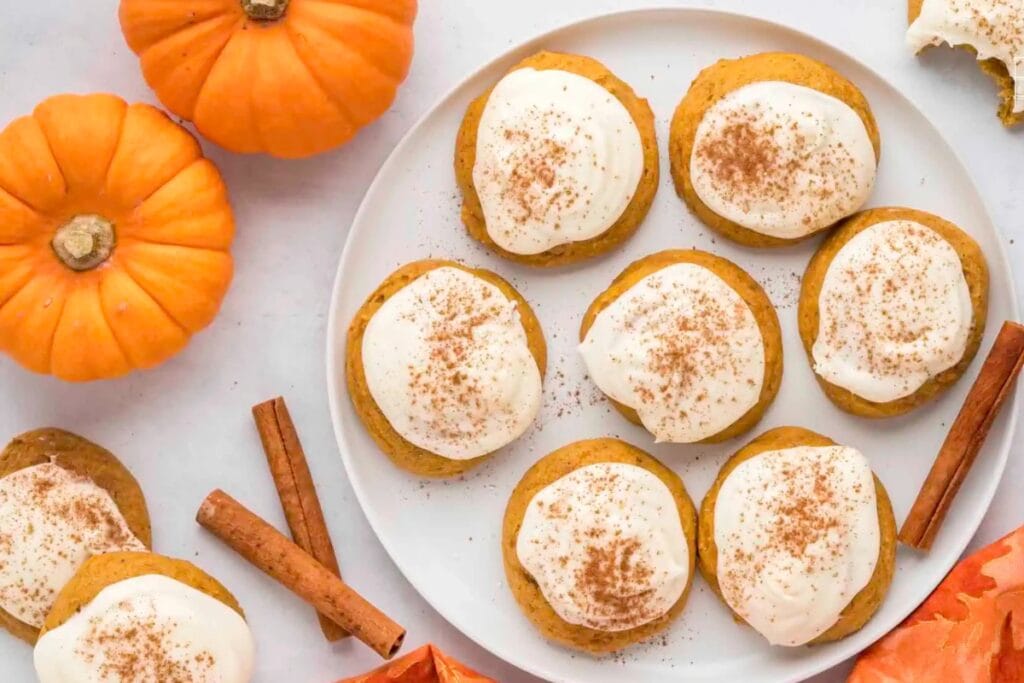 Pumpkin cream cheese cookies with frosting on a plate.
