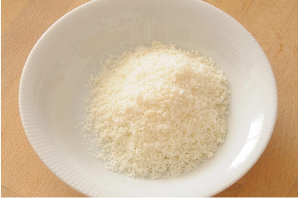 Risparmio grated Parmesan topping in a white bowl.