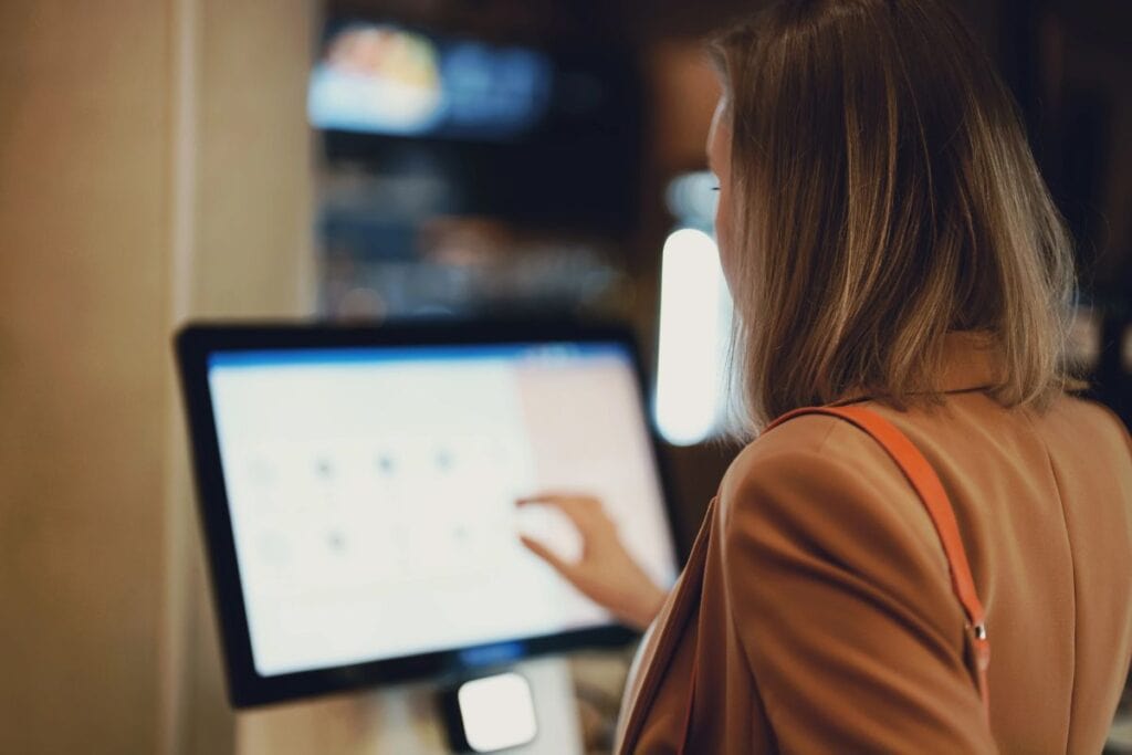 Woman using self-checkout screen.