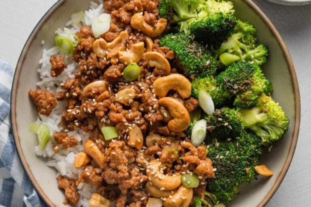 Sesame cashew chicken on a plate with broccoli.