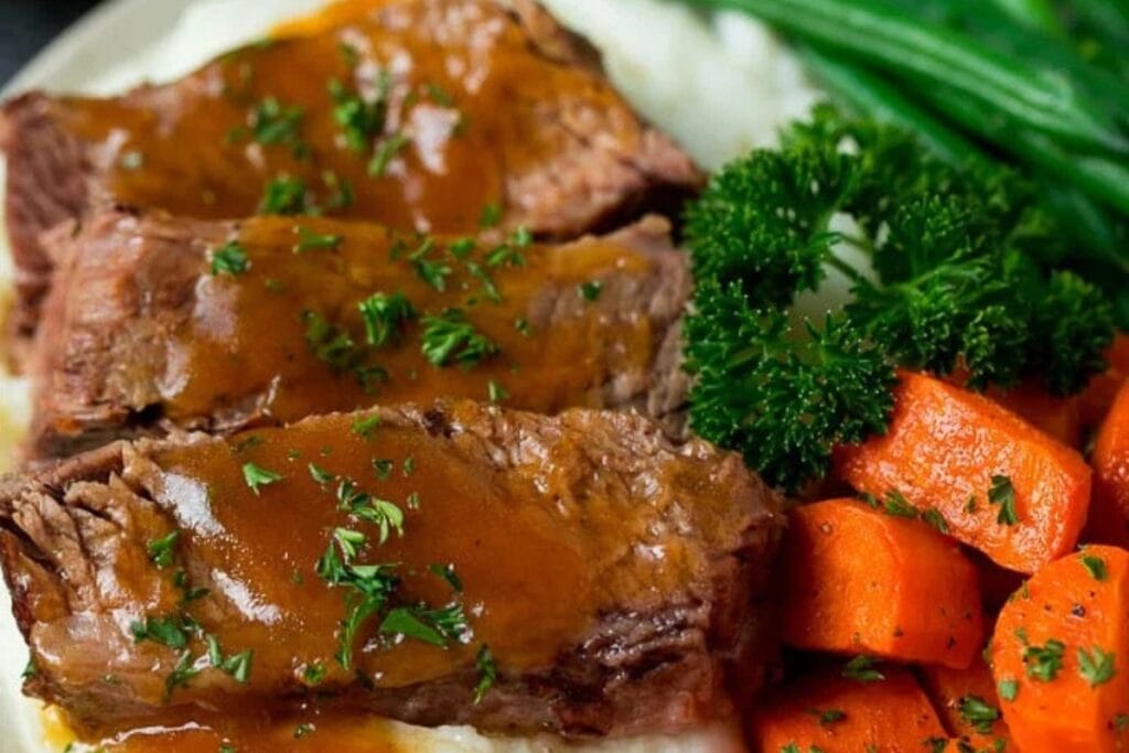 Close up of tender slow cooker brisket on a plate.
