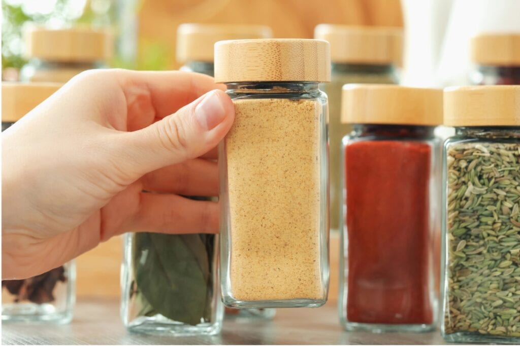 Person handling a Supreme Tradition Garlic Pepper Seasoning bottle.