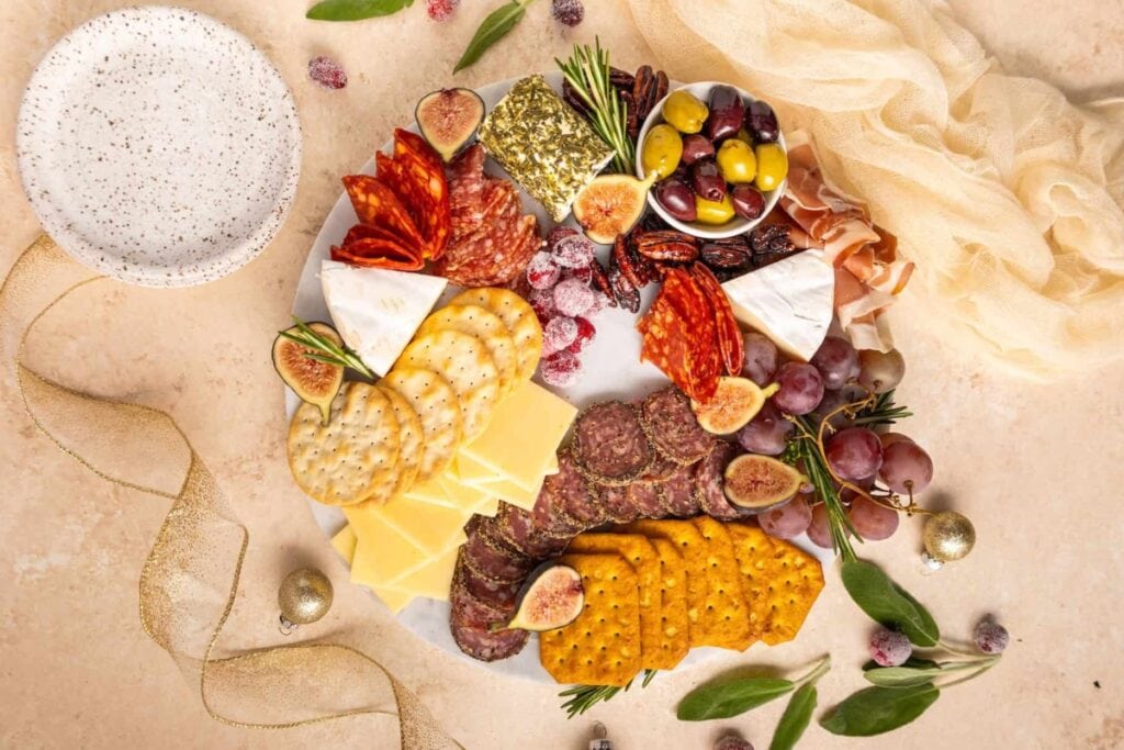 Charcuterie wreath with cheeses, meats, crackers, and fruit.