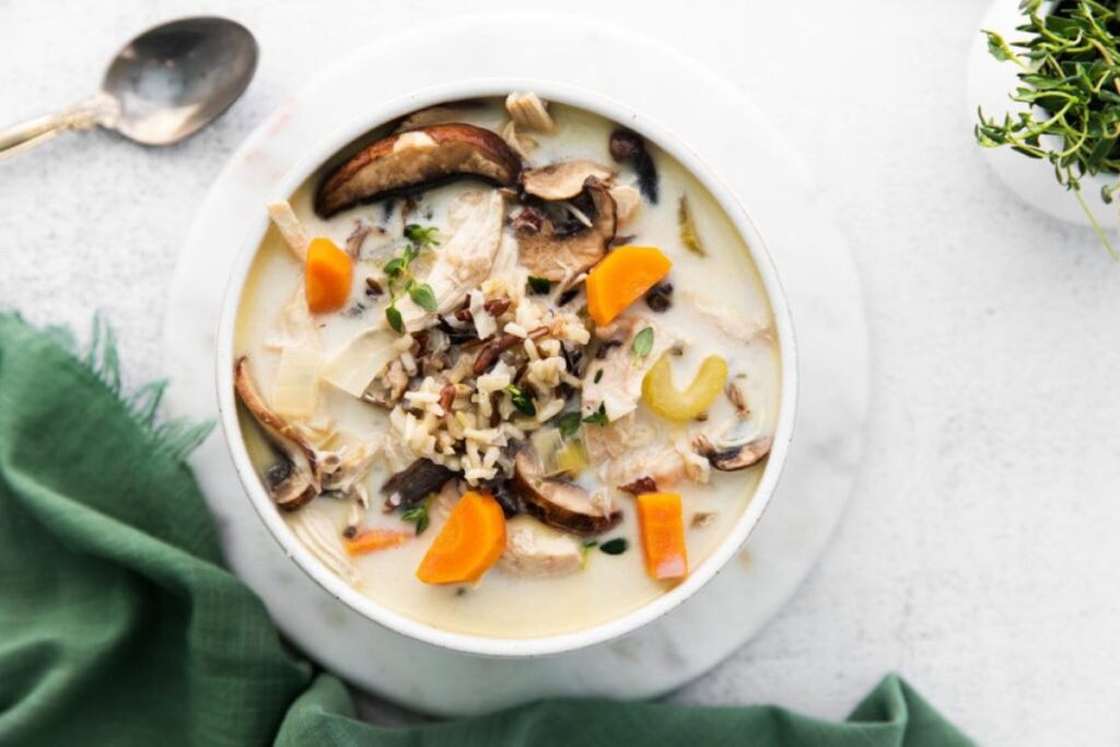 Bowl of chicken wild rice soup with mushrooms and carrots.