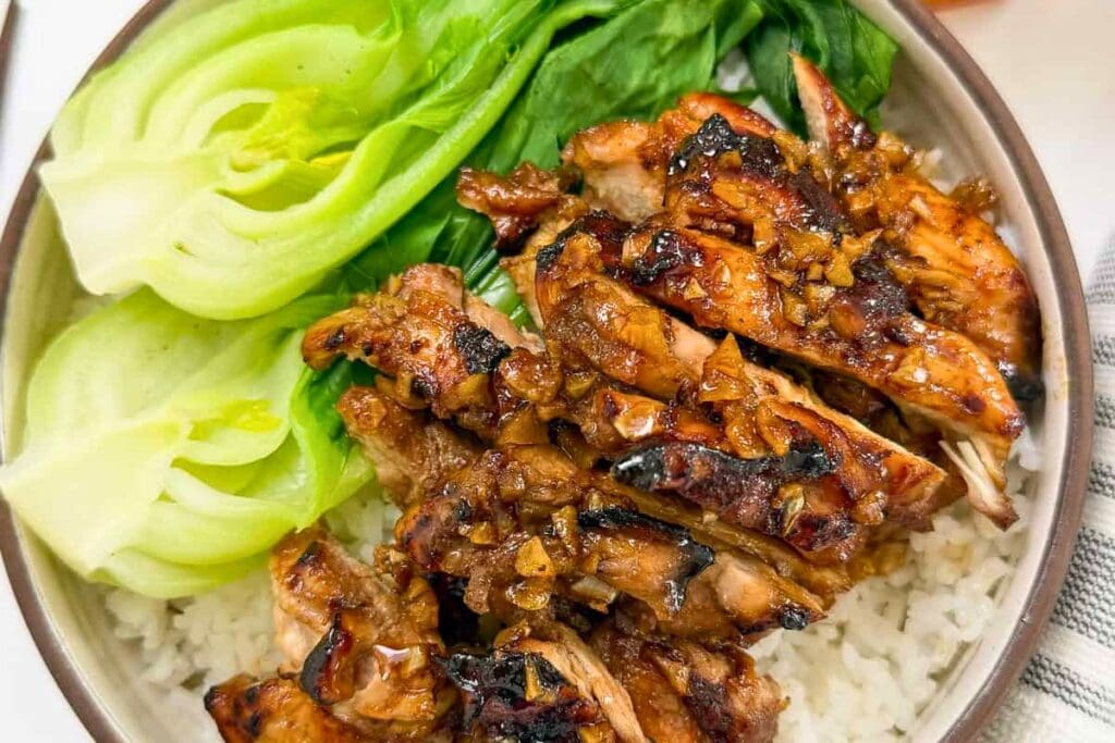 Honey garlic chicken with rice and bok choy in a bowl.