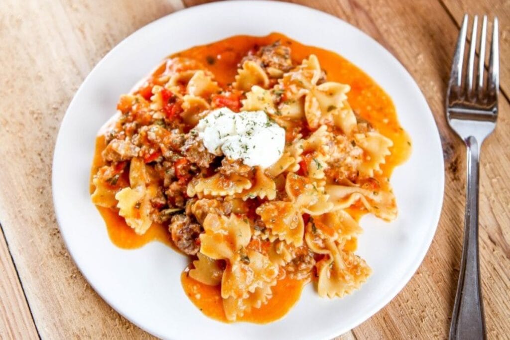 Farfalle pasta with meat sauce and a dollop of ricotta cheese.
