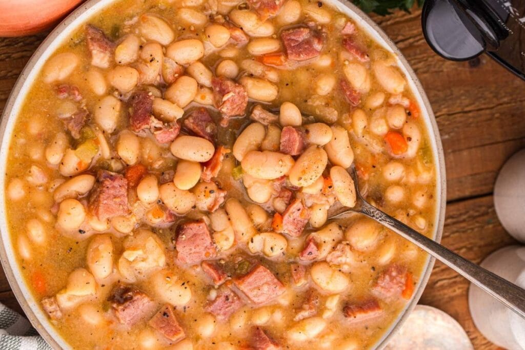 Overhead shot of ham and bean soup with carrots and celery in a bowl.