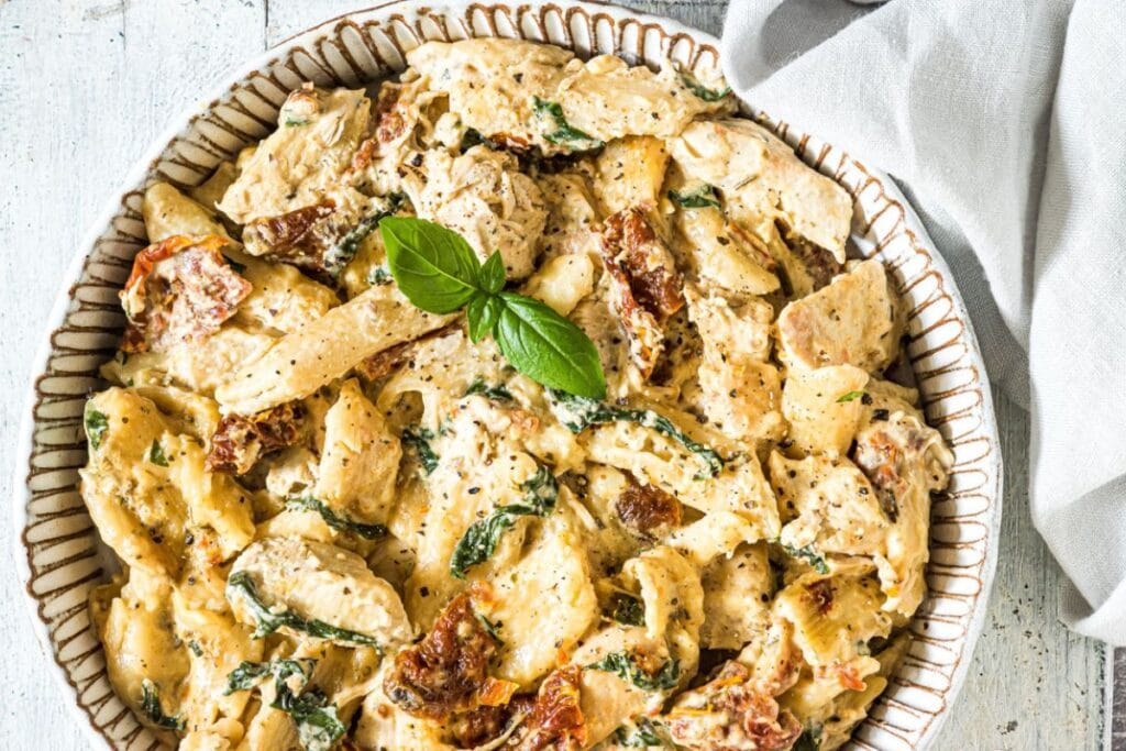 Overhead shot of Tuscan chicken pasta with spinach and sun-dried tomatoes.
