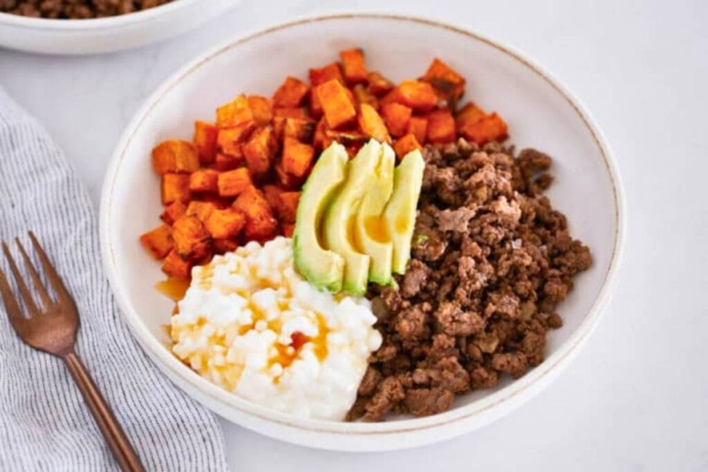 Close-up of a sweet potato beef bowl with avocado and cottage cheese.
