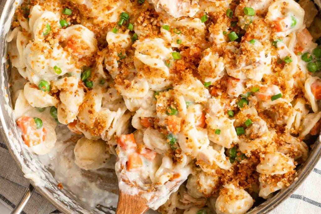 Creamy tuna casserole with shell pasta, peas, carrots, and breadcrumb topping.