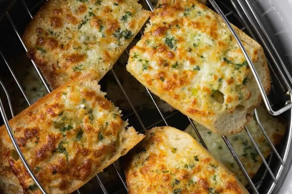 Garlic bread in an air fryer basket.