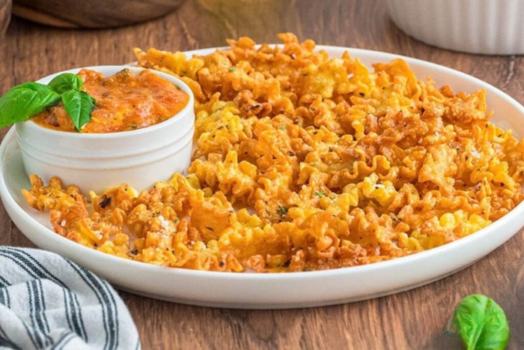 Pasta chips on a plate with dipping sauce.