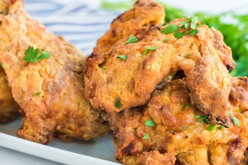Close-up of air fryer southern fried chicken on a plate, garnished with parsley.