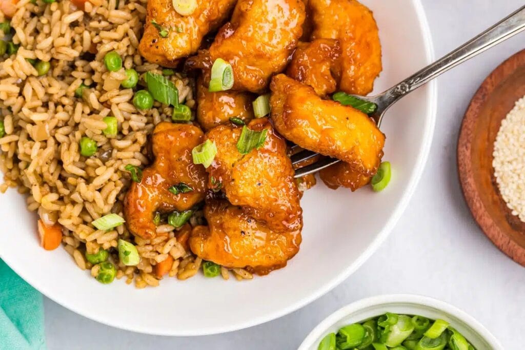 Baked sweet and sour chicken with rice on a plate.