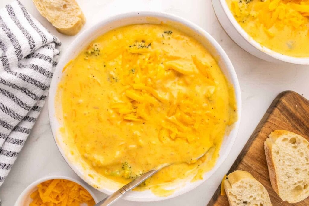 Broccoli cheddar soup in a white bowl with a spoon.