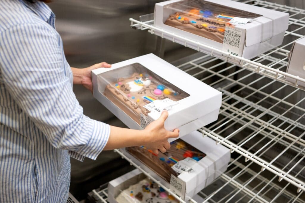 Holding a box of cake.