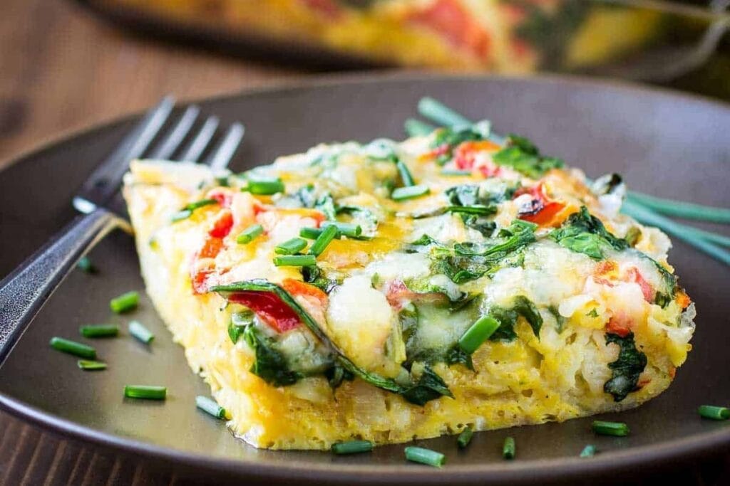 Slice of cheesy tater tot casserole served on a plate.