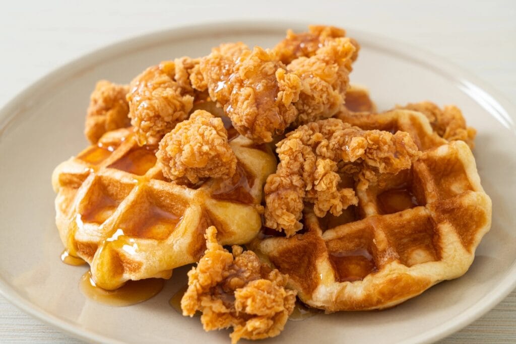 Crispy fried chicken served with golden waffles on a plate.