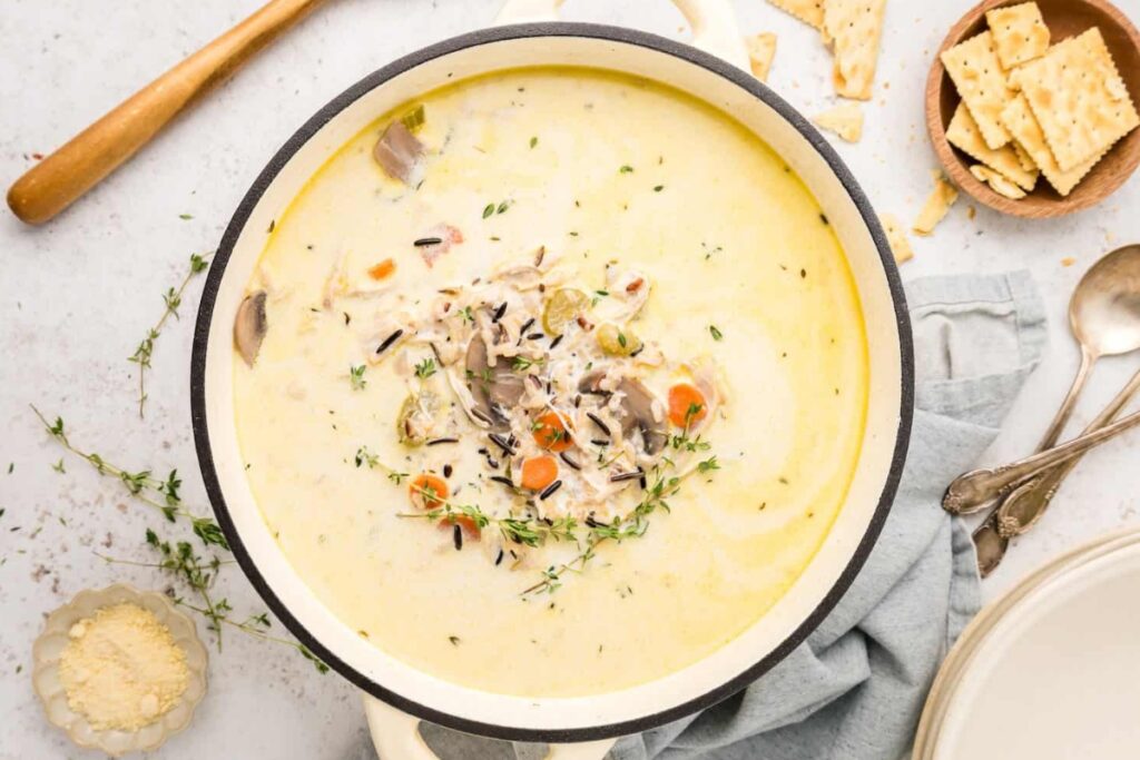 Chicken mushroom wild rice soup in a white pot.