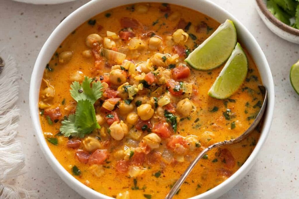 Chickpea curry soup in a bowl topped with lime.