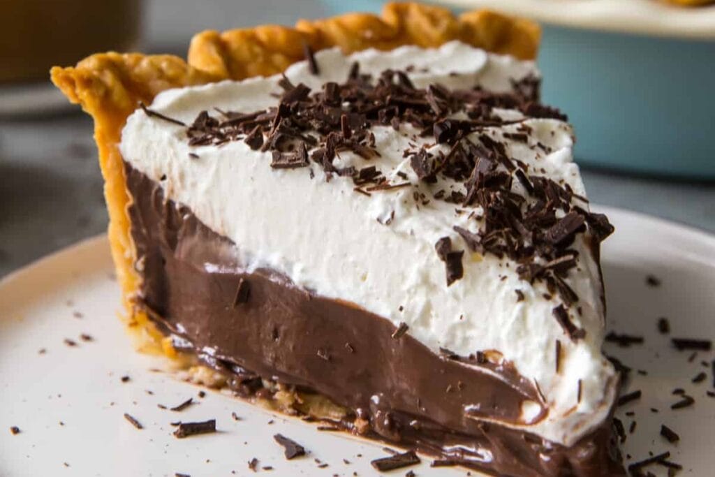 Close-up of chocolate cream pie slice served on a plate.