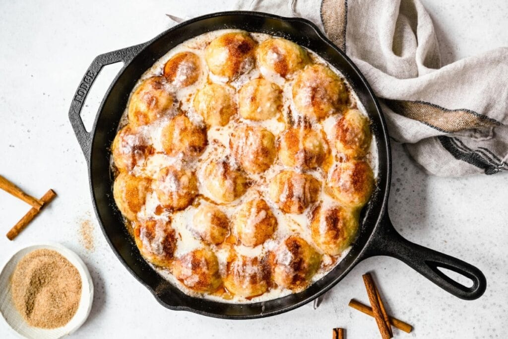 Cinnamon roll bites in a skillet.