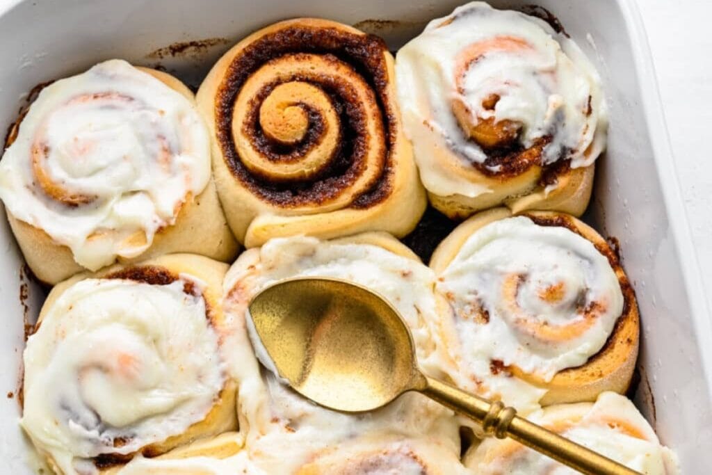 Cinnamon rolls in baking dish with spoon.