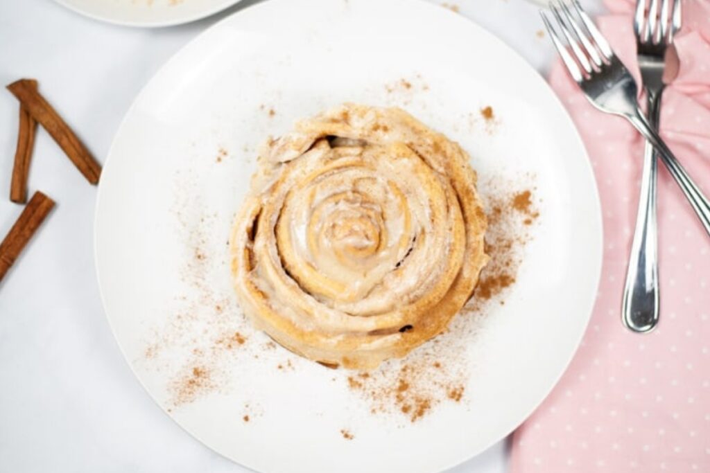Cinnamon roll on a white plate.