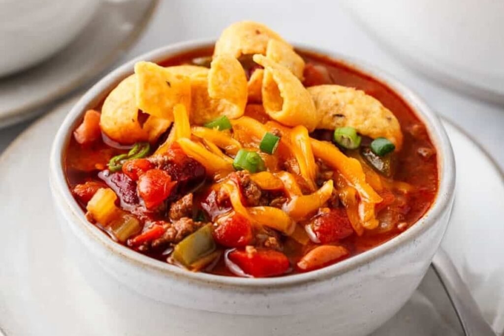 Close-up of Copycat Wendy’s Chili topped with cheese and Fritos in a bowl.