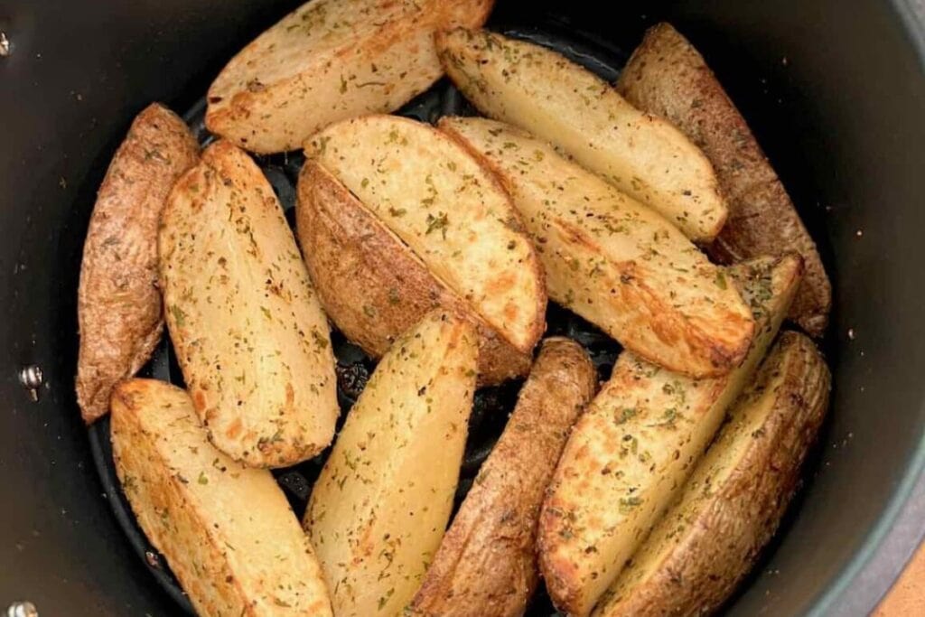 Crispy potato wedges in an air fryer.