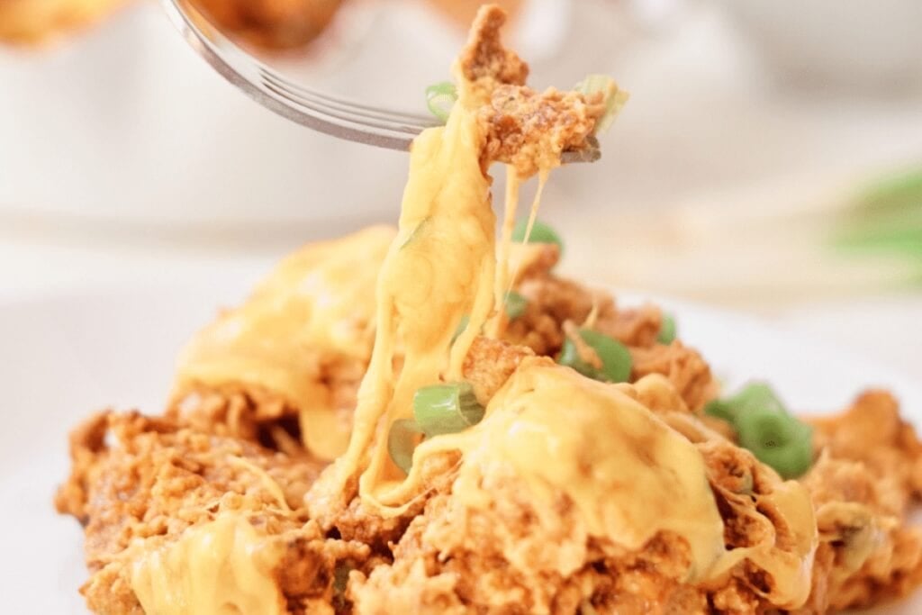 Close-up of Crockpot cheesy bacon ranch chicken on a fork.