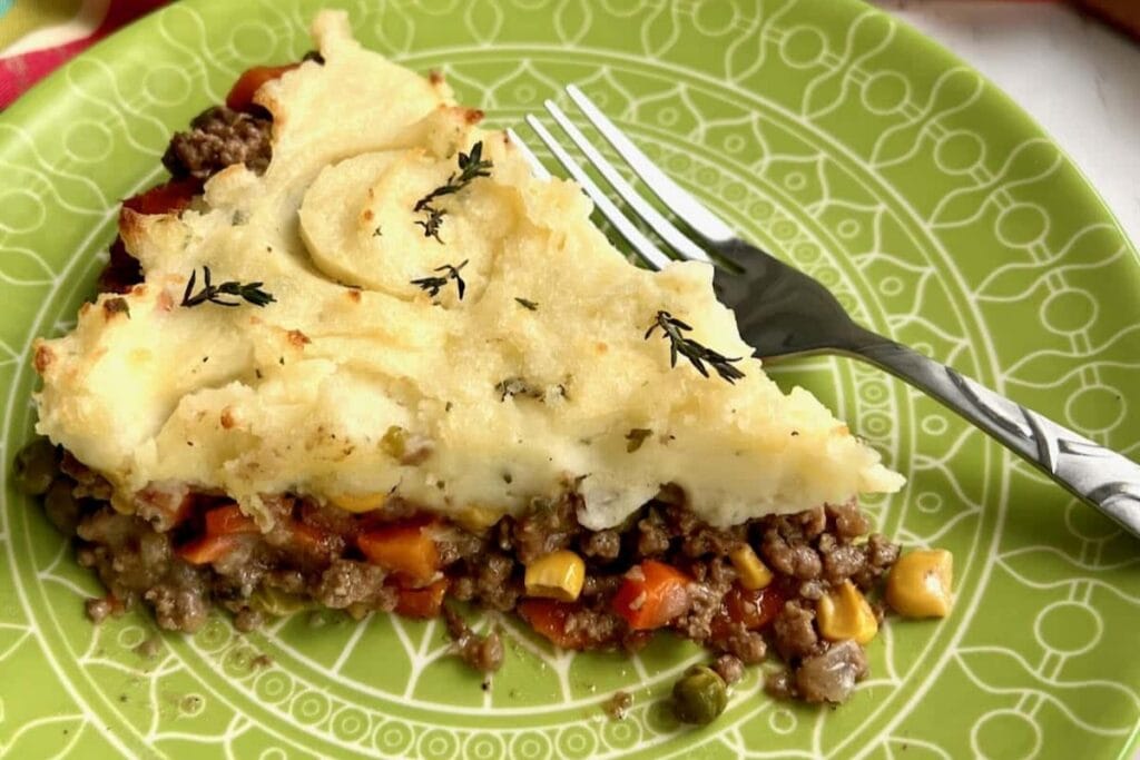 Dutch oven shepherd's pie on a plate with a fork on the side.