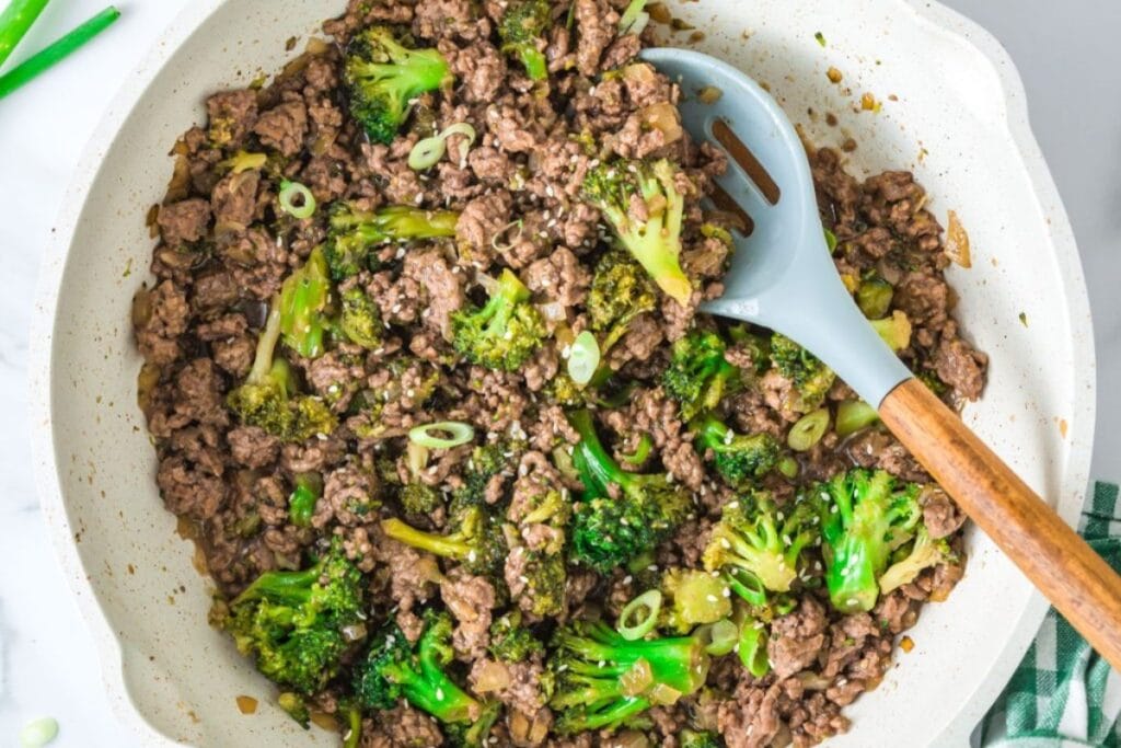 Ground beef and broccoli stir fry in a skillet.