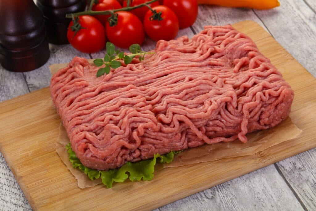 Raw ground turkey on a wooden board.