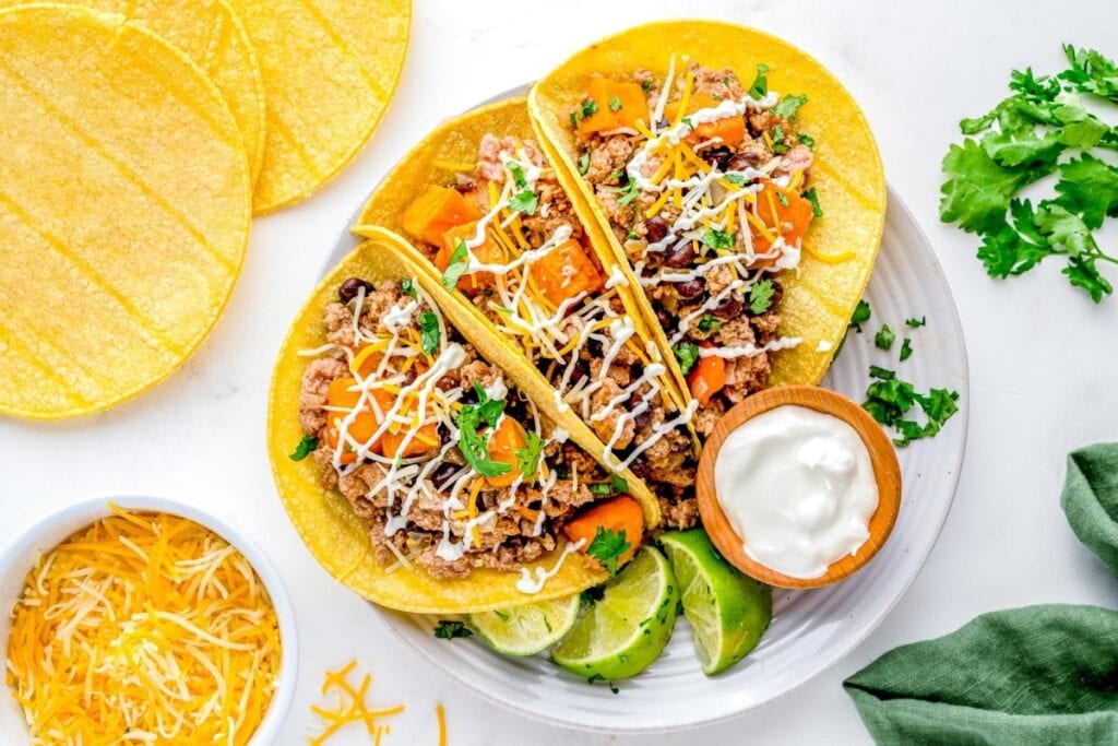Ground turkey tacos with sweet potatoes and dipping sauce on a plate.