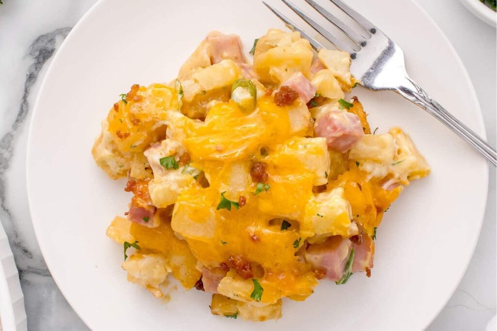 Ham and potato casserole on a plate with fork on the side.