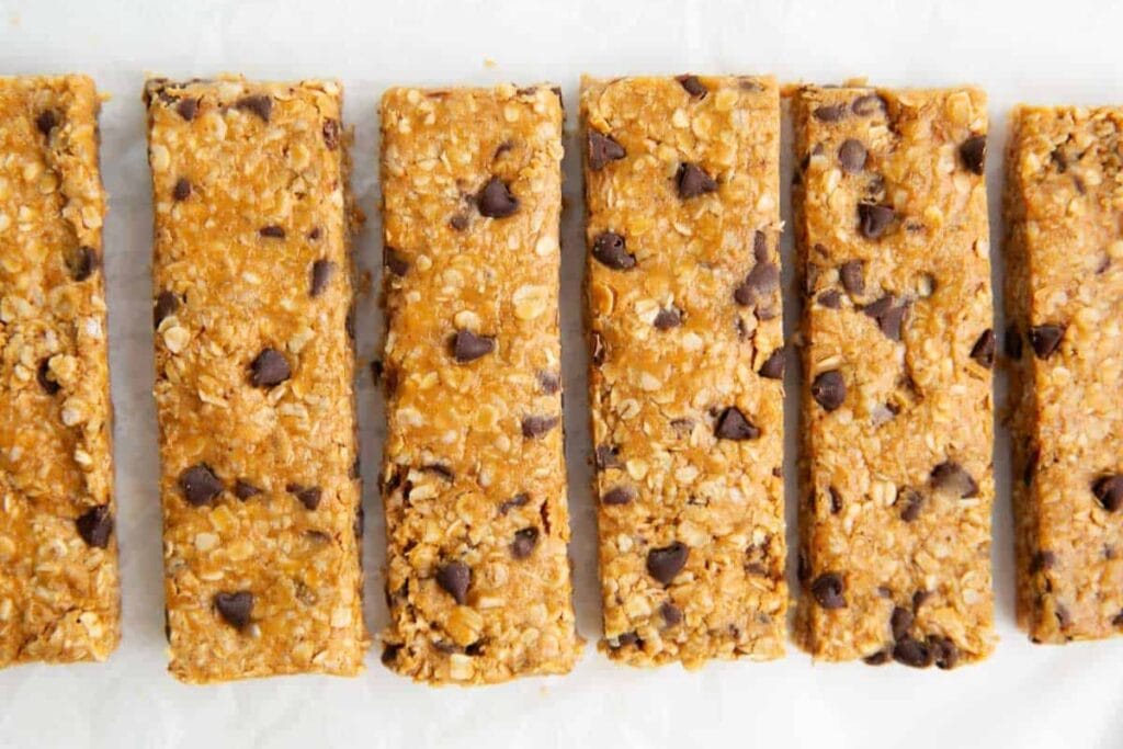 Homemade granola bars with oats and chocolate chips on parchment paper.