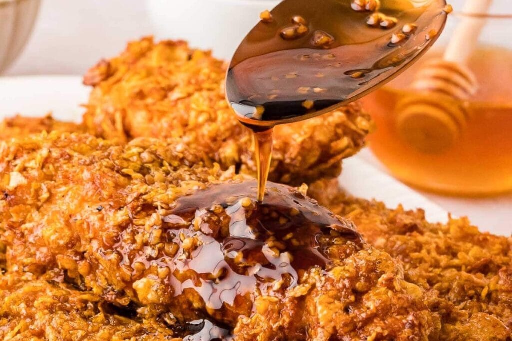 Pouring sauce on honey garlic chicken tenders.