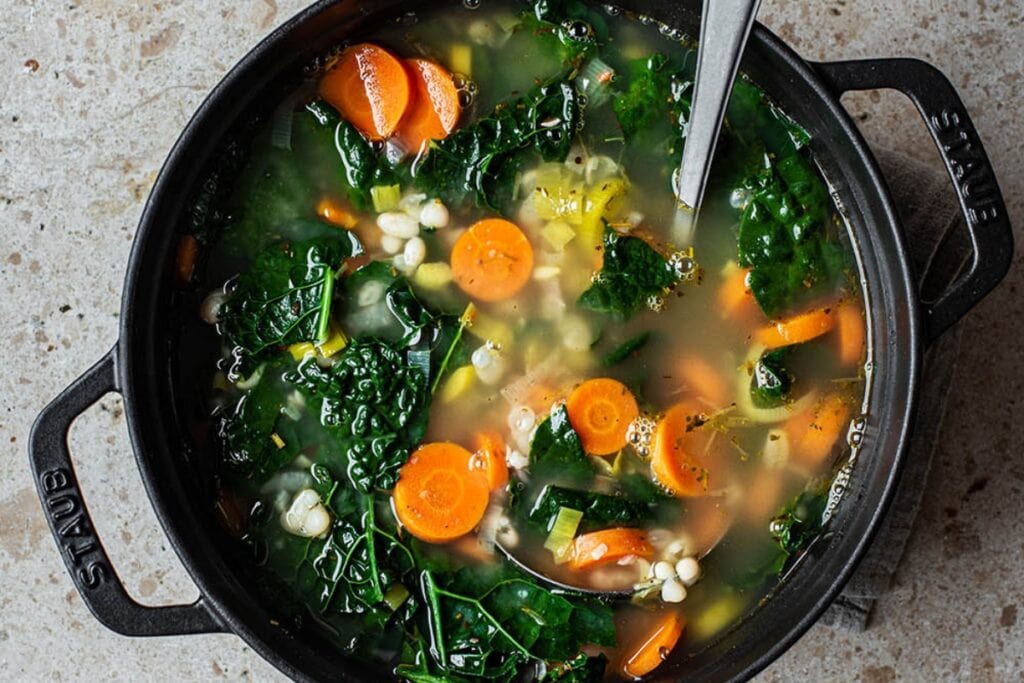 Kale, white bean, and lemon soup in a pot.