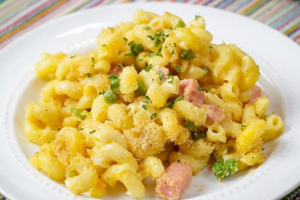 Macaroni and cheese with ham on a plate.