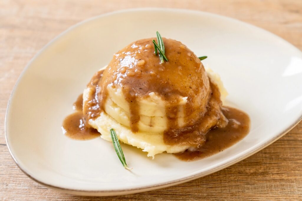 Mashed potatoes with gravy served on a plate.