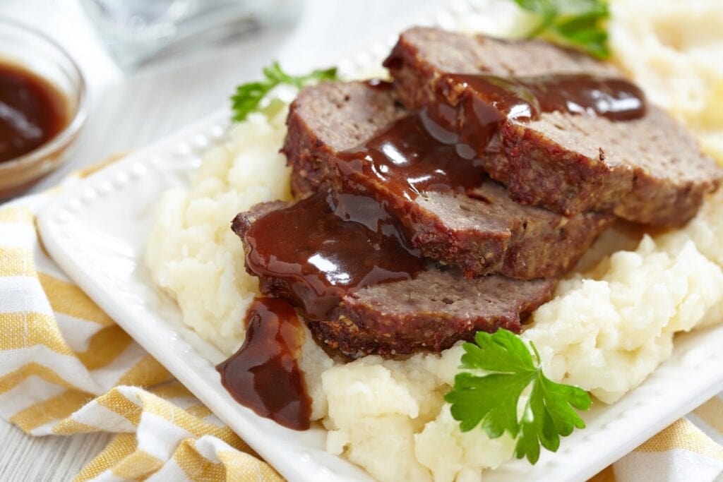 Meatloaf with creamy mashed potatoes served on a plate.