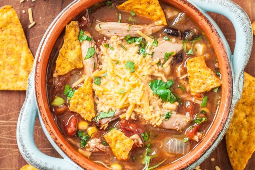 Nacho chicken soup in a handled soup bowl.